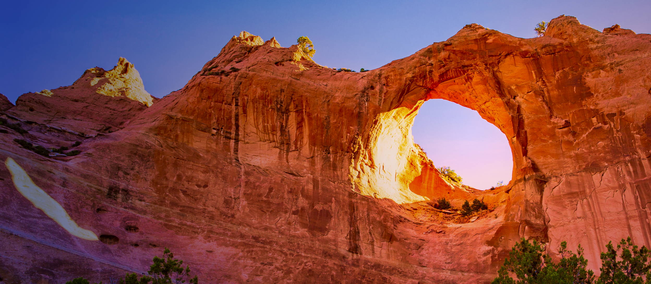 Rock formation with a large hole in the middle against a blue sky