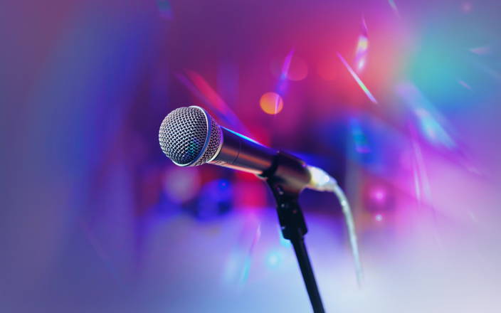 A microphone in front of colorful concert lights for Confetti's Virtual Bar