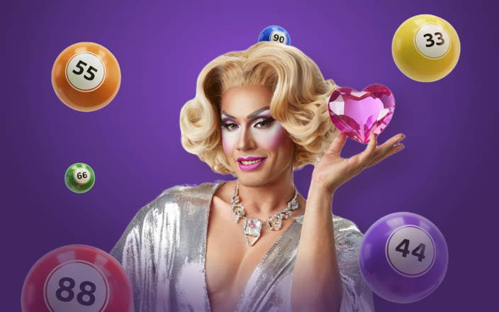 Drag queen in silver gown holding pink crystal heart with bingo balls (preview)