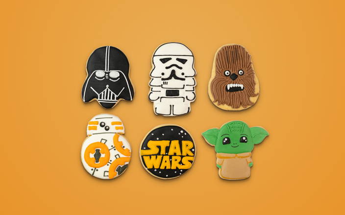 Cookies iced like different characters from the Star Wars franchise for Confetti's Virtual Star Wars Sugar Cookie Decorating Class