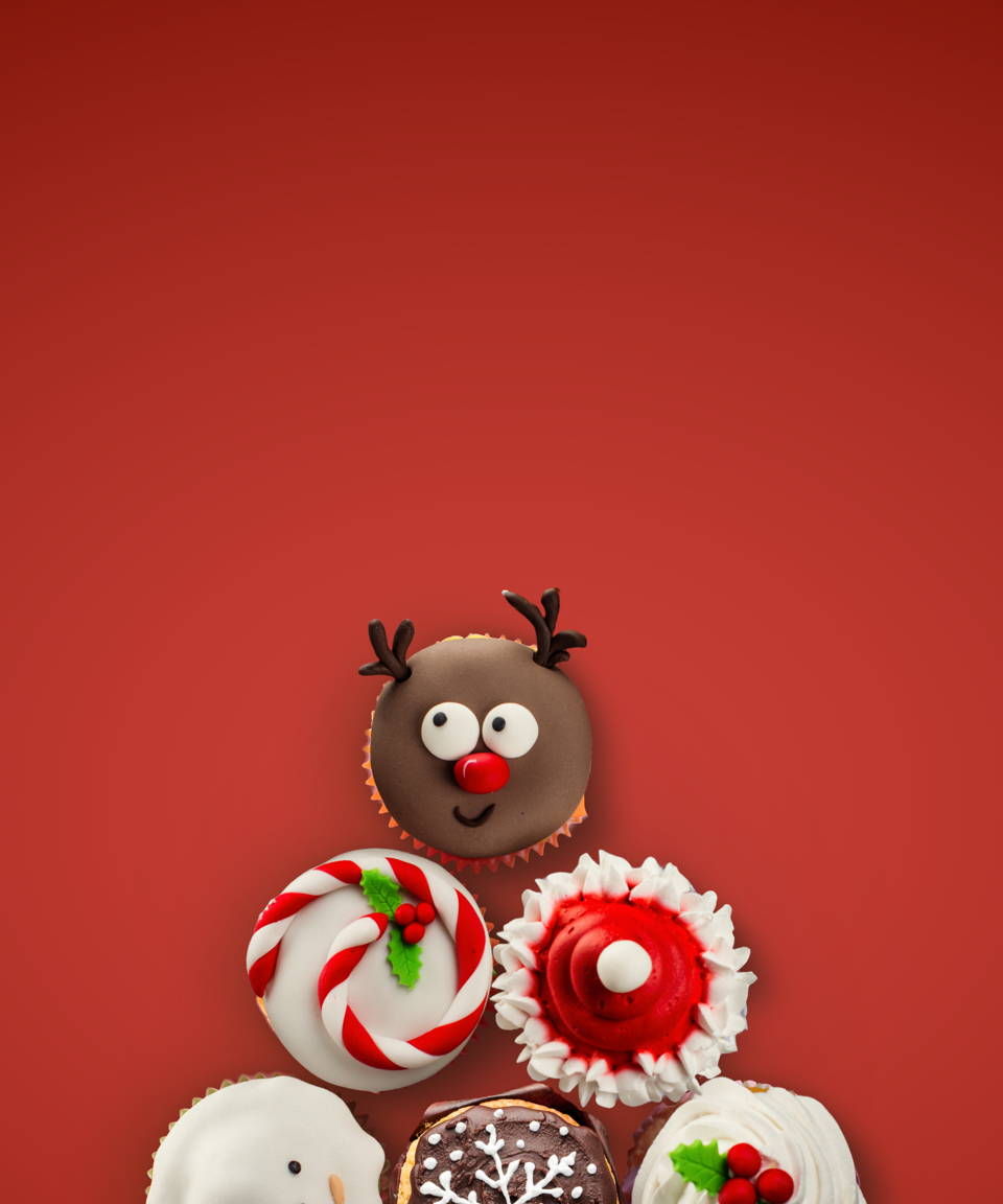 A pyramid of holiday themed cupcakes frosted in various styles for Confetti's Virtual Holiday Cupcake Decorating
