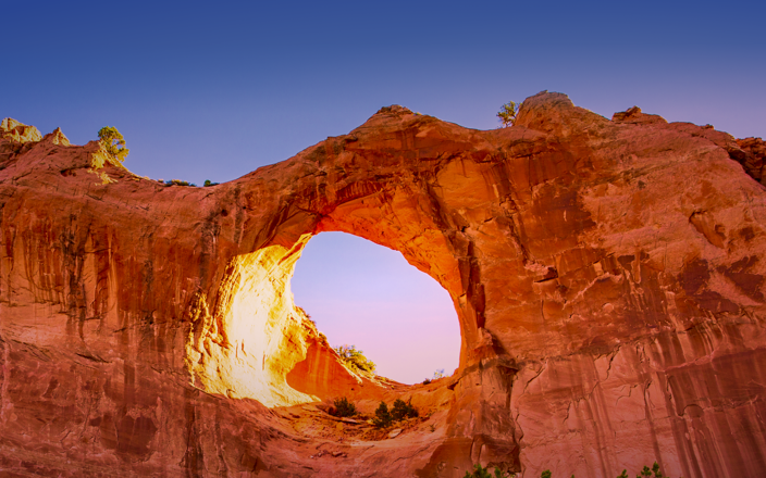 Rock formation with a large hole in the middle against a blue sky