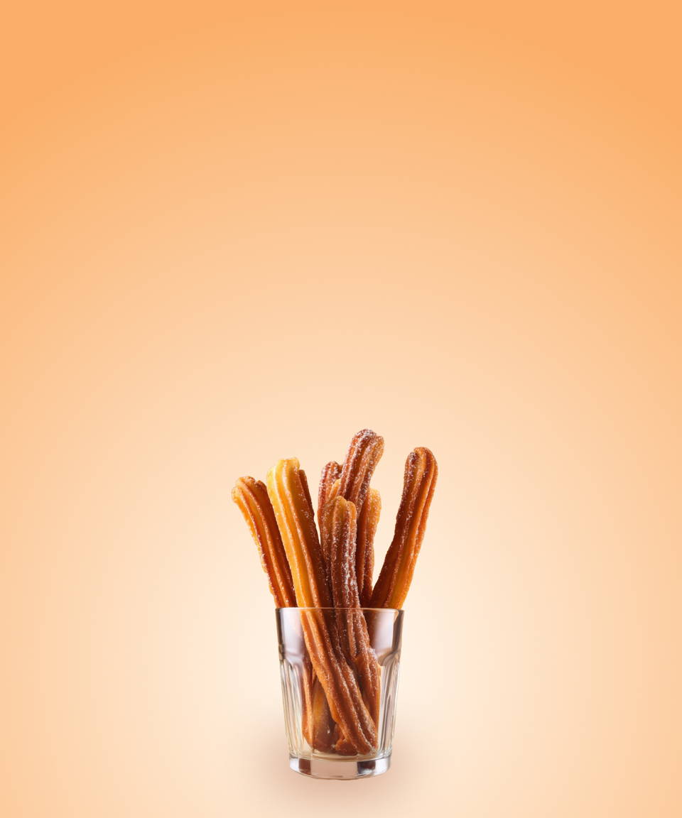 Sugar and cinnamon coated deep fried churros in a glass cup (small)