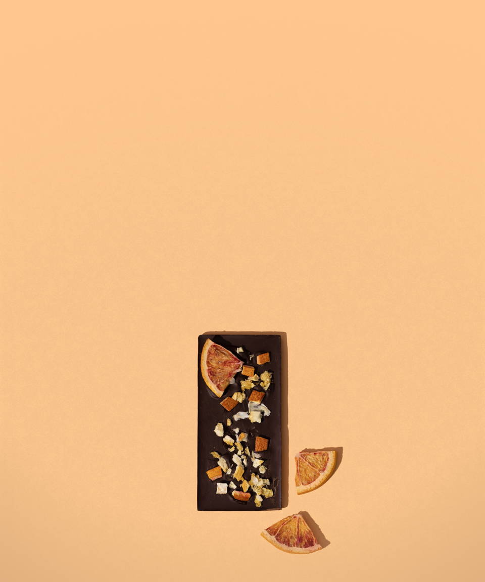A chocolate bar topped with chopped nuts and dried oranges for Confetti's Virtual Chocolate Bar Making Class 