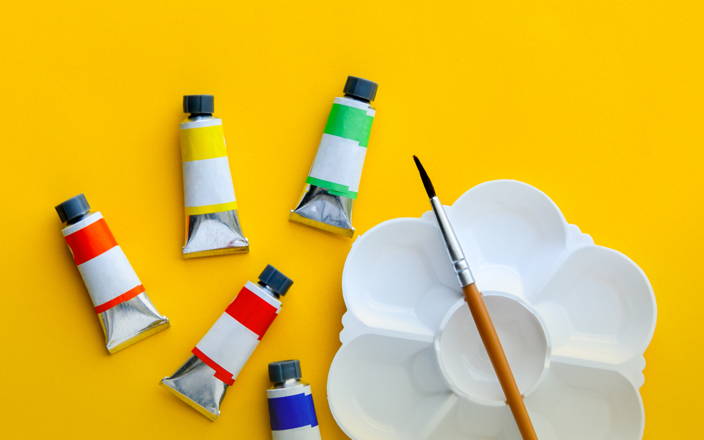 various paints, a paint brush, and an empty palette for Confetti's Virtual BYO Team Building Painting Class