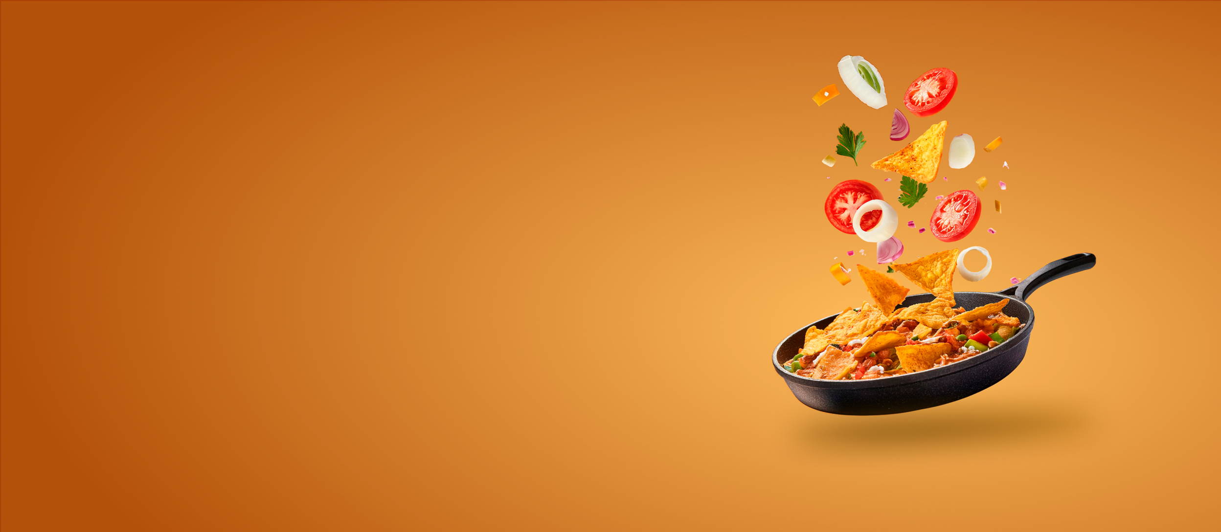Chilaquiles cooking in a pan with vegetable garnishes floating on top (large)