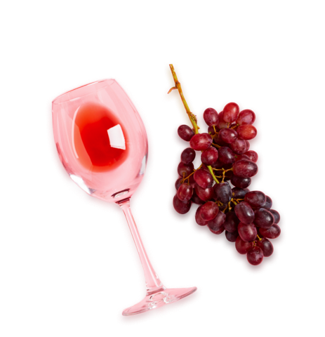 Almost empty red wine glass and a bunch of grapes