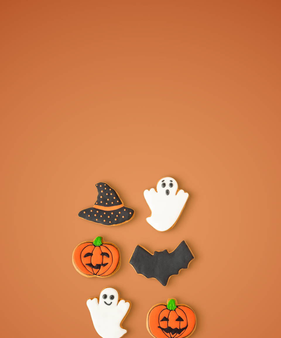 Cookies shaped like a witches hat, ghosts, bats, and pumpkins for Confetti's Virtual Halloween Cookie Decorating