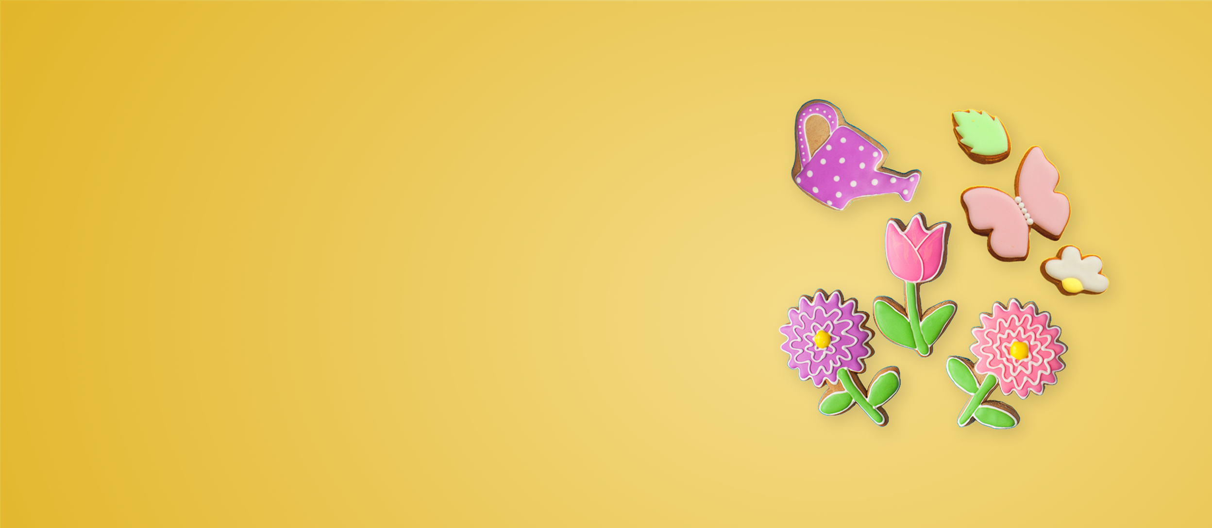 Spring cookies shaped like flowers, butterflies, and a watering pail for Confetti's Virtual Spring Cookie Decorating Class