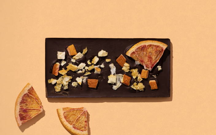 A chocolate bar topped with chopped nuts and dried oranges for Confetti's Virtual Chocolate Making Course