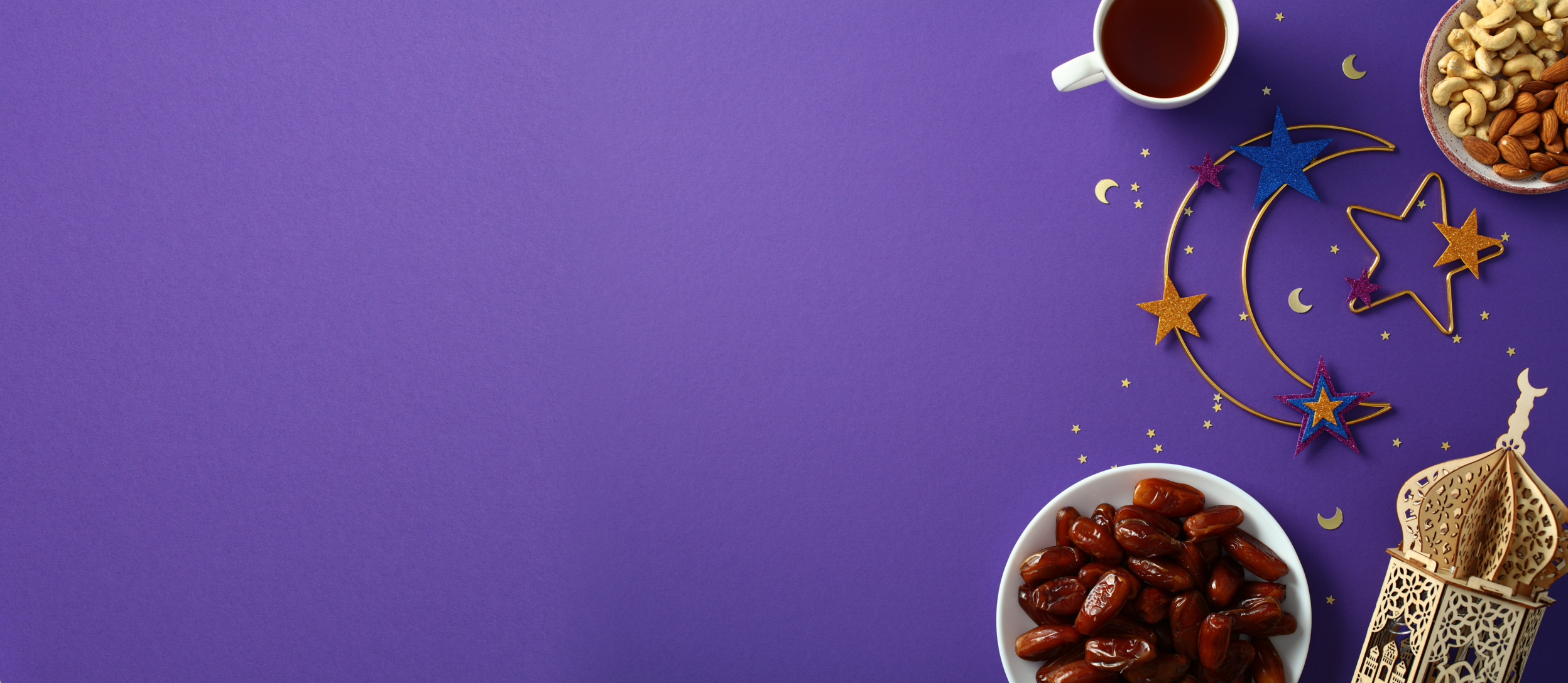 Purple background with moon and stars, small bowls of food, a small building, & a mug
