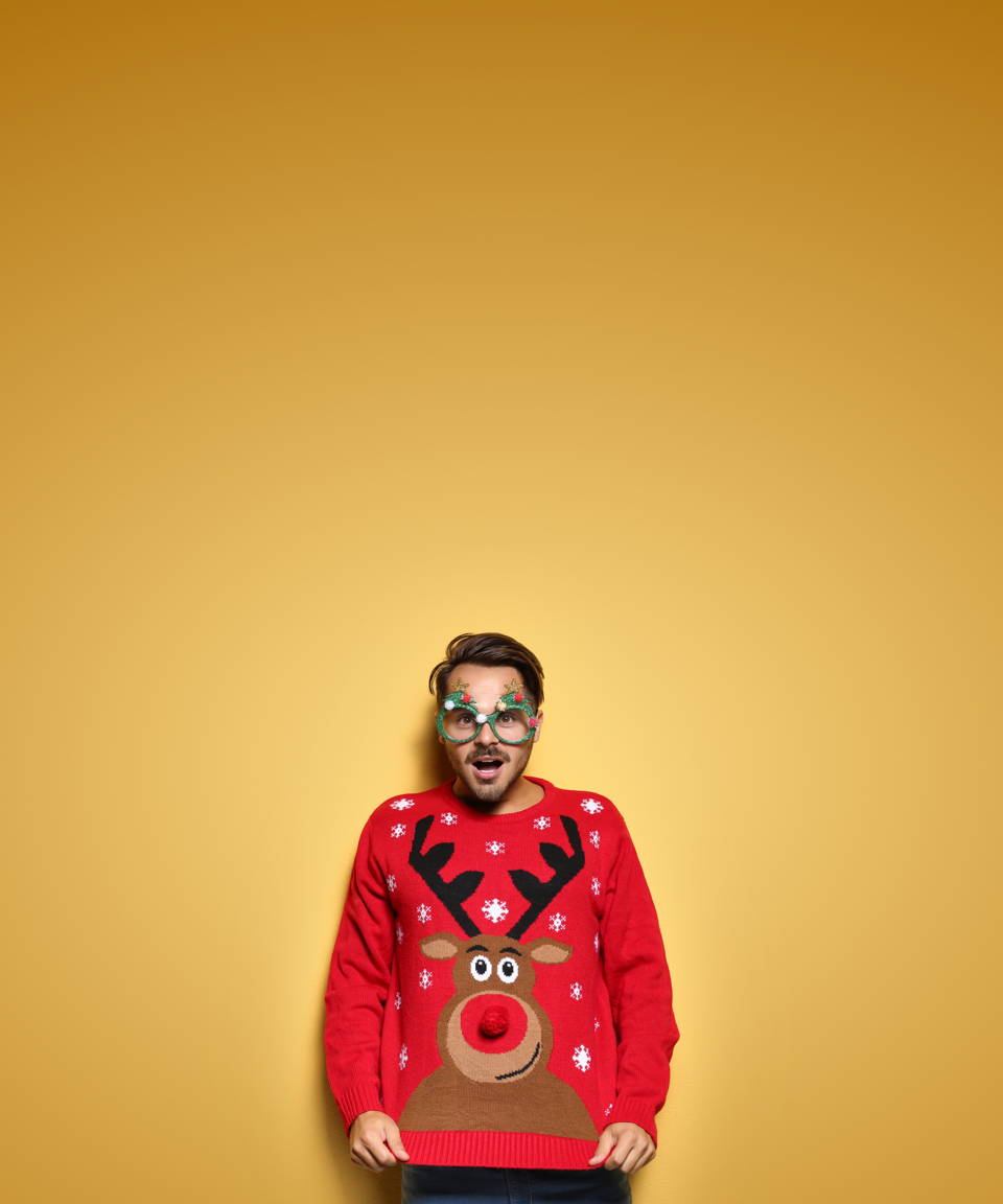 A guy wearing goofy Christmas tree glasses and a reindeer sweater for Confetti's Virtual Ugly Sweater Making Party