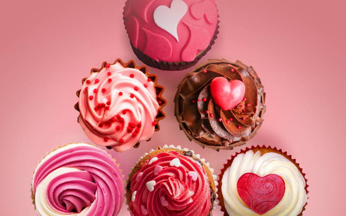 Cupcakes frosted in pink and red Valentine's Day themed decorations for Confetti's Valentine's Day Cupcake Decorating Class