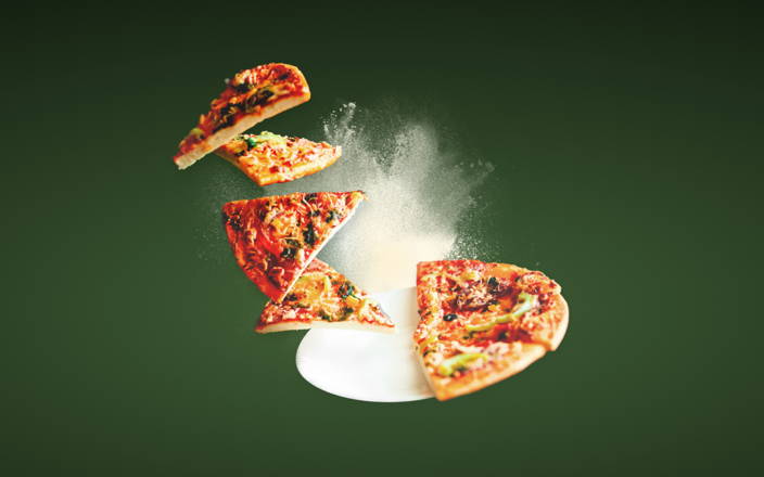 A full pizza with half of the slices levitating off the plate for Confetti's Virtual Italian Cooking Classes