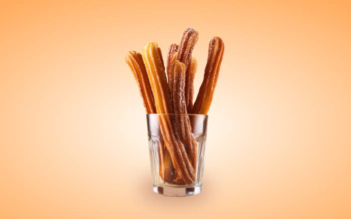Sugar and cinnamon coated deep fried churros in a glass cup (preview)