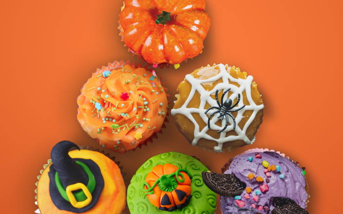 Halloween decorated cupcakes with pumpkins, witch hats, and spiders (preview)