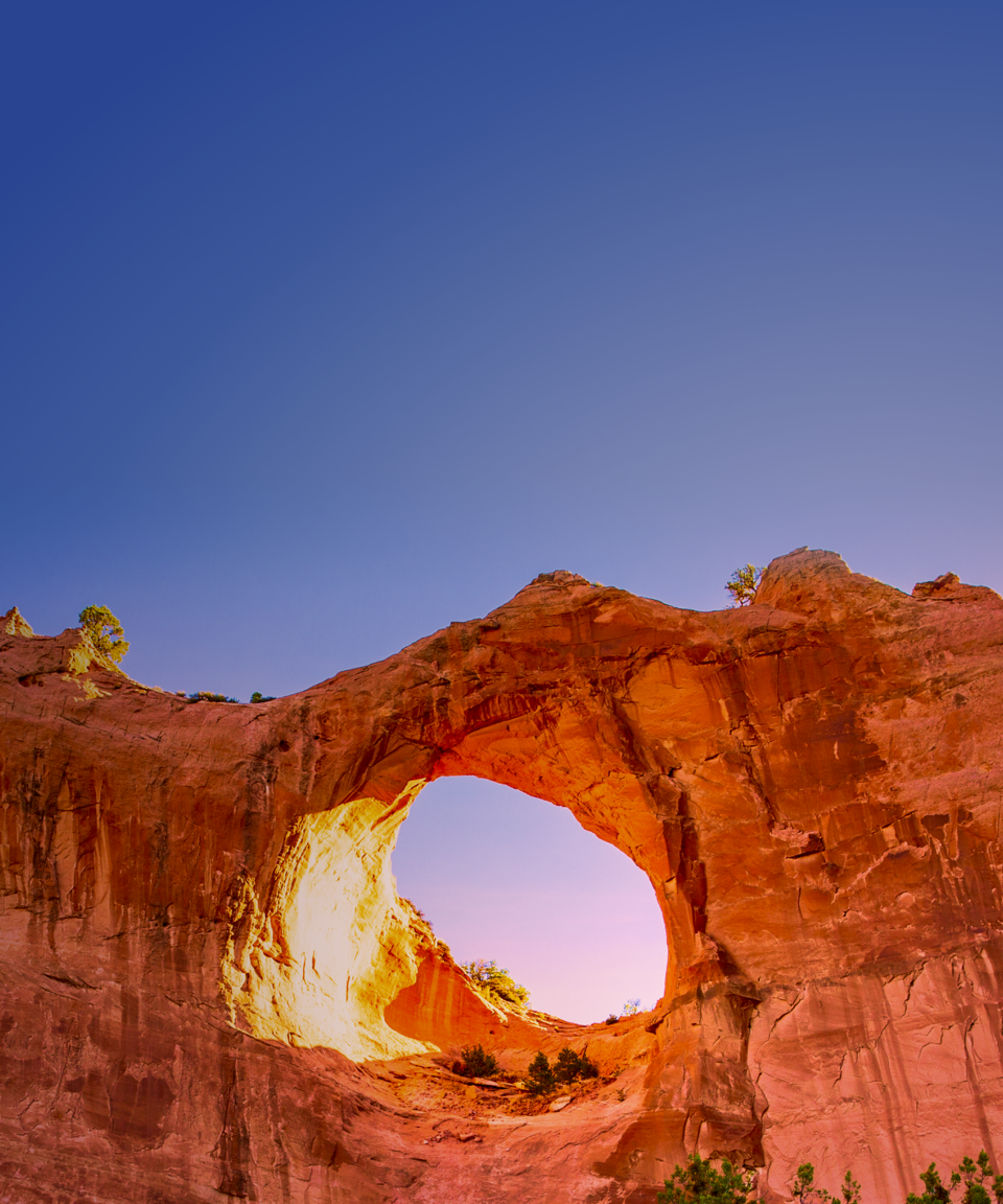 Rock formation with a large hole in the middle against a blue sky