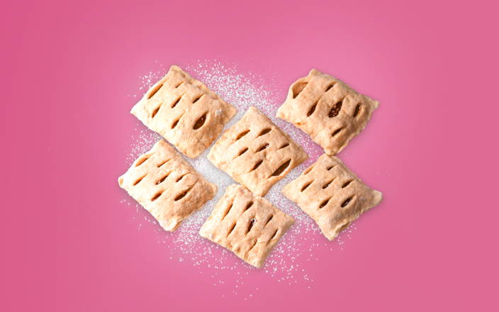 Baked hand pies in mid-air with powdered sugar for Confetti's Virtual Pie Making Classes